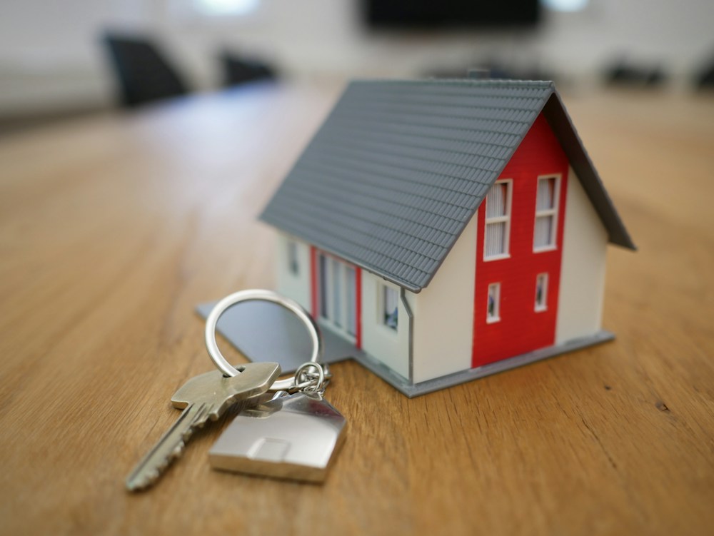 Casa em miniatura com chaves, representando negócios imobiliários
